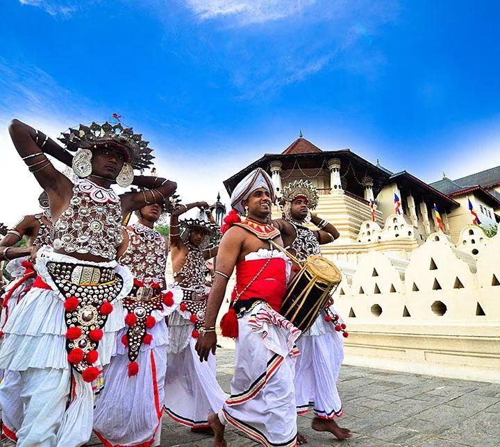 Kandyan dancers in silver headdresses and a drummer outside the Temple of the Tooth